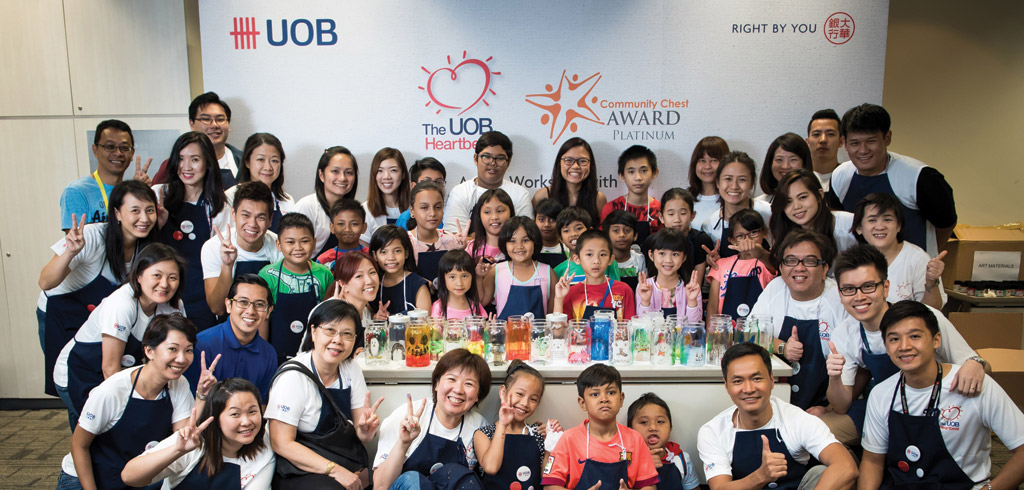UOB volunteers with the children from Punggol Family Service Centre and artist Ms Lee Jia Zhen, winner of the Most Promising Artist of the Year award at the 2014 UOB Painting of the Year (Singapore) competition